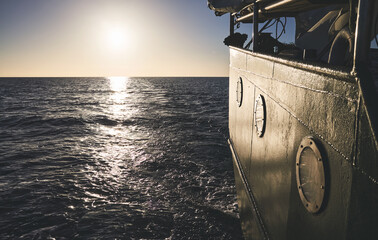 Stern of an old ship at sunset, travel or homesickness concept.