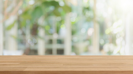 Empty wood table top and blurred of interior restaurant with window view green from tree garden background background - can used for display or montage your products.
