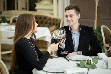 Couple having dinner at a restaurant and making a toast