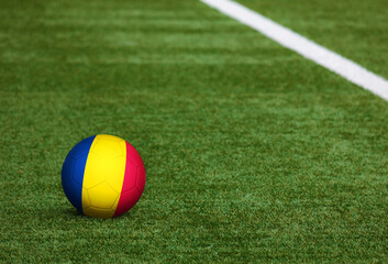 Plakat Chad flag on ball at soccer field background. National football theme on green grass. Sports competition concept.