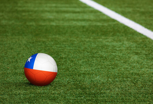 Chile flag on ball at soccer field background. National football theme on green grass. Sports competition concept. - Powered by Adobe