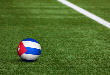 Plakat Cuba flag on ball at soccer field background. National football theme on green grass. Sports competition concept.