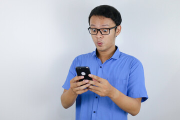 Fototapeta premium Young asian man shocked and happy when he looking smartphone