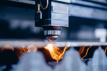 CNC laser machine cutting sheet metal with light spark. Technology plasma industrial, Blue steel...