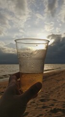 Vaso de cerveza al atardecer en la playa