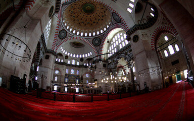 Fototapeta na wymiar View into the interior of the Süleymaniye Mosque in Istanbul, with domes, prayer room, windows and numerous calligraphies.