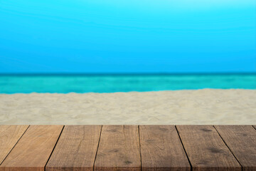 Top of wood table with seascape , blur light of calm sea sand and sky at tropical beach .