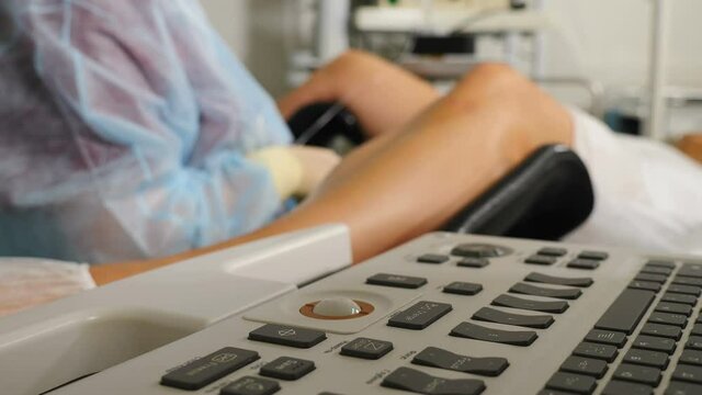 Gynecological surgery, Close-up. Blurred view gynecologist performing operation using monitoring ultrasound machine IVF follicular puncture for oocyte retrieval. shot through ultrosound keyboard. 4 k