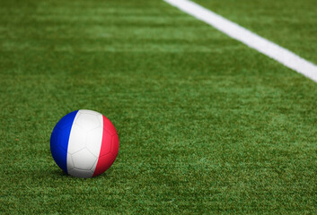 Plakat France flag on ball at soccer field background. National football theme on green grass. Sports competition concept.