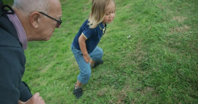 Preschooler studying nature with his grandfather