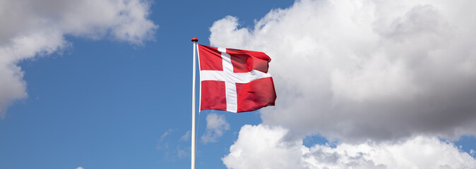 Danish flag with blue sky and clouds