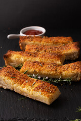 Food appetizer ideas for party concept homemade organic garlic bread stick on black slate board with copy space