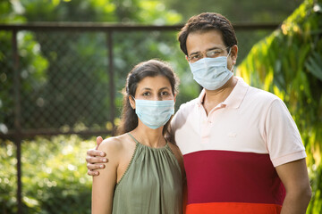 Couple with protective face mask at park