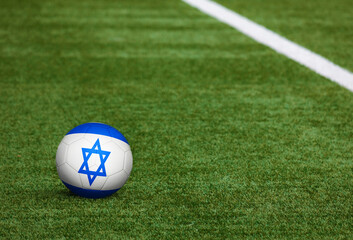 Fototapeta na wymiar Israel flag on ball at soccer field background. National football theme on green grass. Sports competition concept.