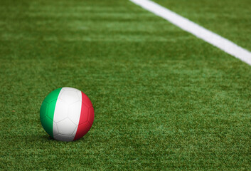 Fototapeta na wymiar Italy flag on ball at soccer field background. National football theme on green grass. Sports competition concept.