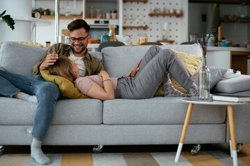 Obraz premium Husband and wife enjoying on sofa. Happy couple relaxing in living room. 