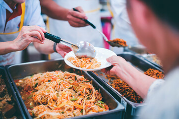 Food donation to the poor : The hands of the homeless are waiting to receive food from volunteers