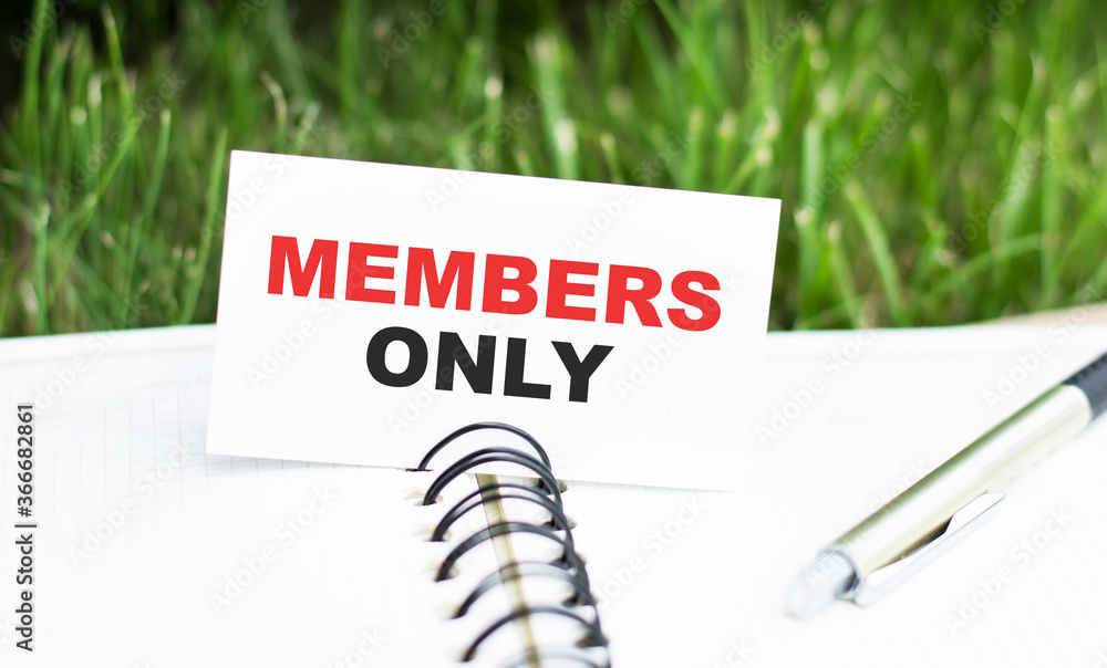 Poster members only text on the card lying on the notebook