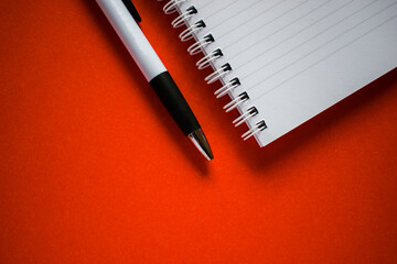 Cut out notepad and pen on orange background