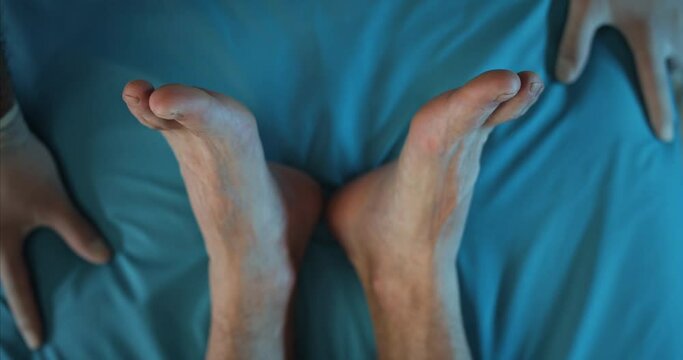 Close up of person feet and paramedics hands on medical transportation cart. Crop view of patient riding on ambulance to hospital. Concept of healthcare, illness, accident