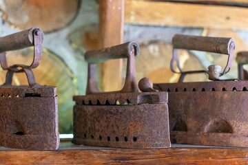 A few antique vintage irons standing in a row on the counter