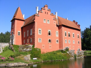 Naklejka na ściany i meble view of a water castle surrounded by a lake with distinctive red plaster, Southern Bohemia, Czech Republic