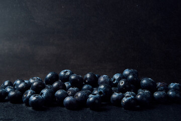 Freshly juicy picked blueberries on dark background. Concept of healthy eating 