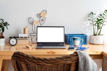 Laptop on office desk with white empty monitor, coffee, plant, phone and pencil. Screen with mockup...