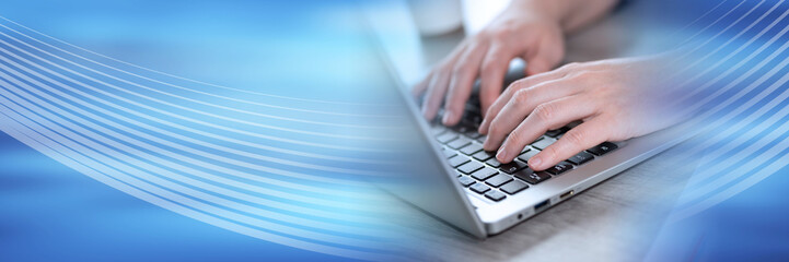 Female hands using laptop; panoramic banner