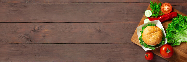 Ingredients for making a burger. Burger on a dark wooden background. Top view, flat lay. Banner