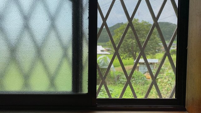 窓越しの畑とのどかな風景。地方移住/帰省イメージ写真素材。
