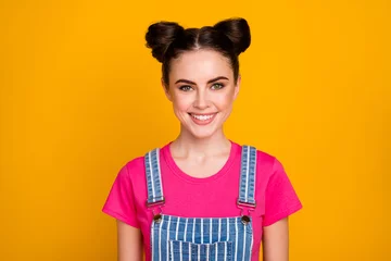 Poster Photo of pretty brunette lady teenager two cute buns good mood beaming smile wear casual striped denim overall magenta t-shirt isolated bright yellow color background © deagreez