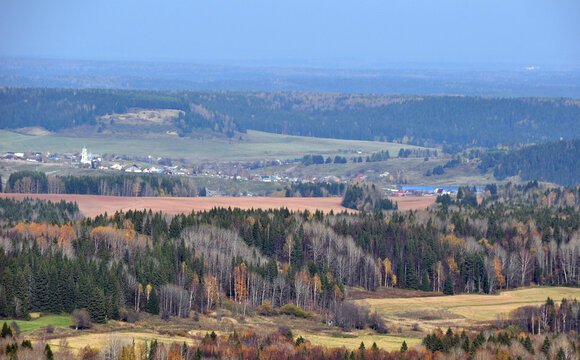 The expanses of the Western Urals. Panorama of autumn forests and fields overlooking the village of Bym from the top of the White Mountain.