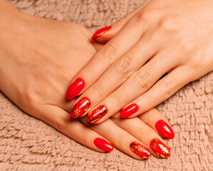 Female hands with red manicure on soft fur textile.