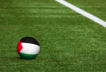 Fototapeta na wymiar Palestine flag on ball at soccer field background. National football theme on green grass. Sports competition concept.
