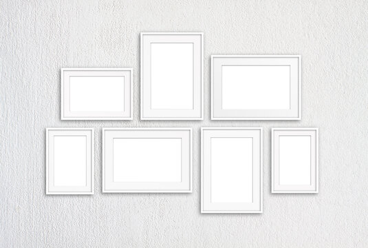 White photo frames collage isolated on white textured wall