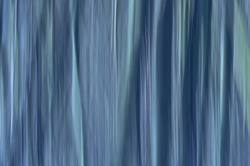 Obraz premium Abstract motion blurred background with vertical lines in cold blue tints.