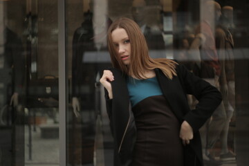 The girl in black coat. Beautiful emotional young girl in the city. Shawl or handkerchief on a person. 