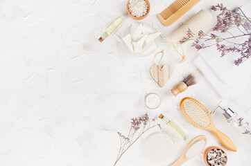 Elegant eco accessories for aromatherapy, massage with cosmetic products, perfume, essential oil, dry herbs on soft light white background, top view, border.