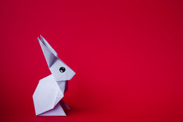 Simple flat lay out. White rabbit paper origami on clear background with copy space concept