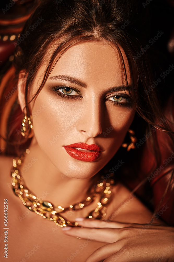 Poster seductive woman in golden jewelry