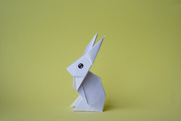 Simple flat lay out. White rabbit paper origami on clear background with copy space concept