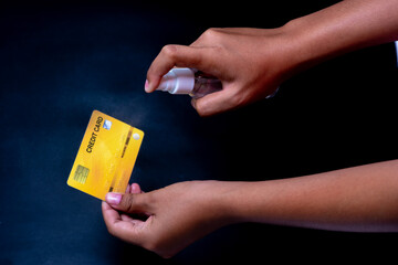 Spray at hand and credit card showing how to destroy germs-Covid-19