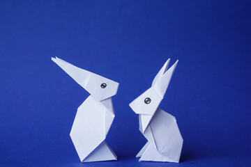 Simple flat lay out. two White rabbits paper origami on clear background with copy space concept
