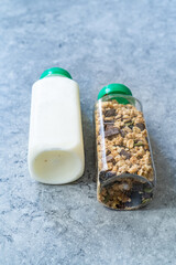 Roasted Granola in Plastic Bottle with Pumpkin Seeds, Chocolate Drops, Honey and Milk.