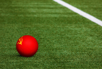 Soviet Union flag on ball at soccer field background. National football theme on green grass. Sports competition concept.