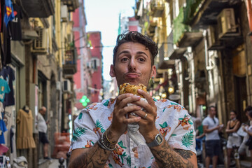 Young man eating street food in Italy during the holidays