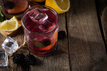 Blackberry lemonade on rustic wood background, copy space