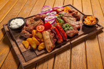 Mixed grilled meats and sausages served on wooden board