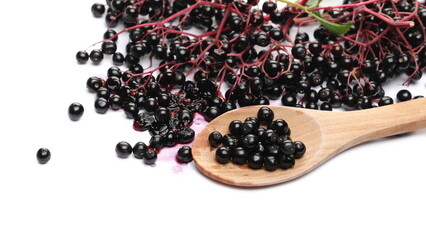Elderberries, elder plant berries with wooden spoon isolated on white background